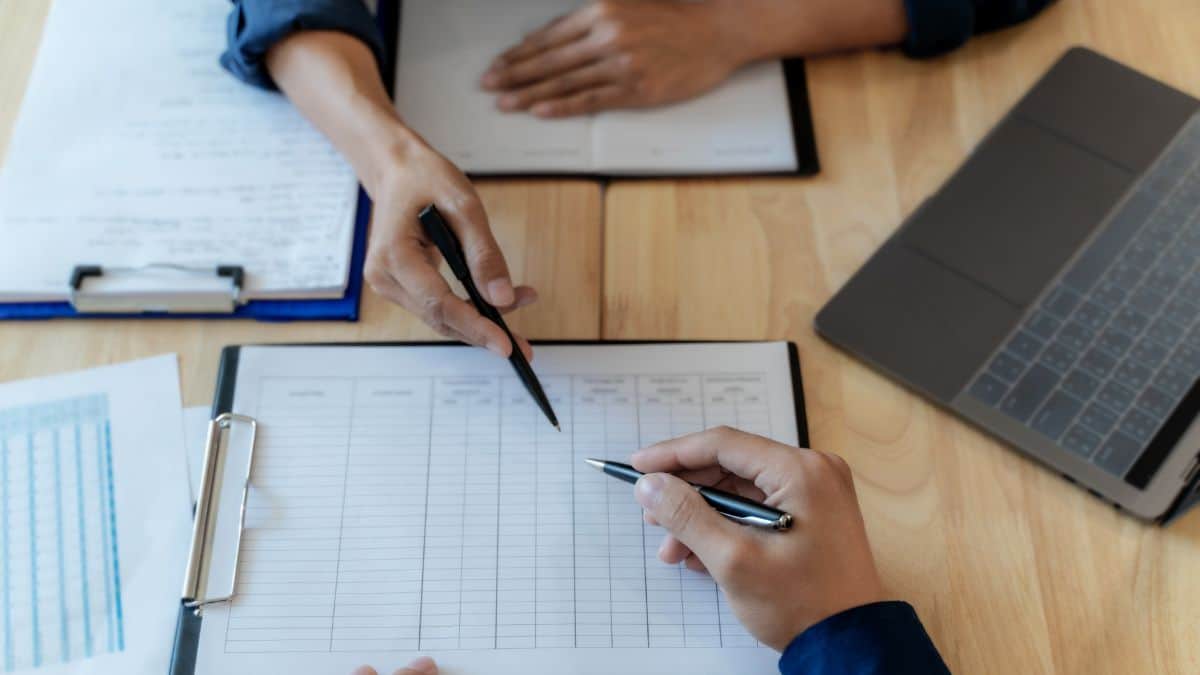 A photo of two people discussing the paper on the table